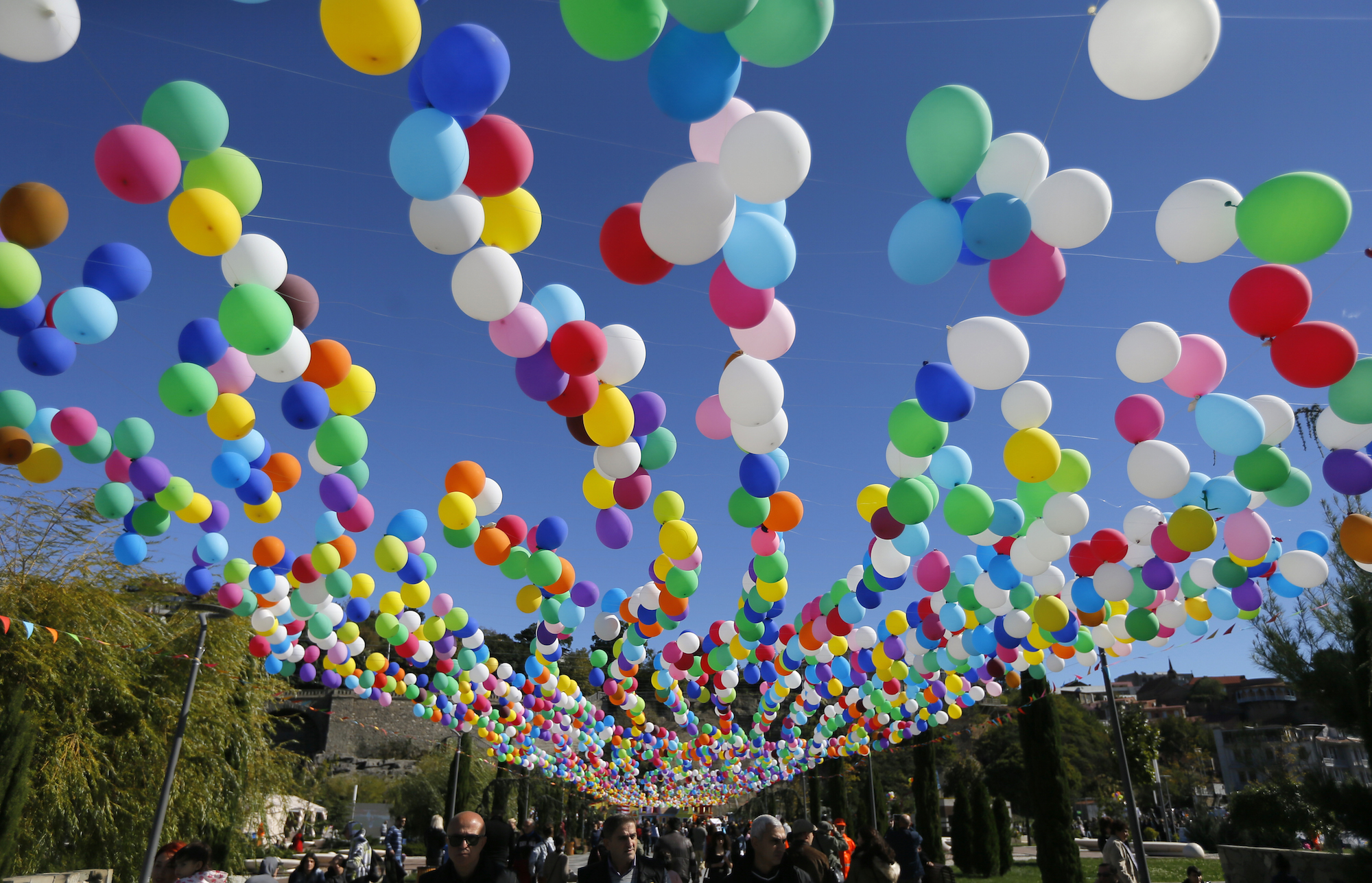epa05586454 Georgian people walk under balloons as they attend the 'Tbilisoba' celebrations in Tbilisi, Georgia, 15 October 2016. The annual festival is dedicated to the Georgian capital of Tbilisi.  EPA/ZURAB KURTSIKIDZE